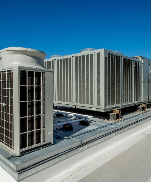 A couple of air conditioners sitting on top of a roof